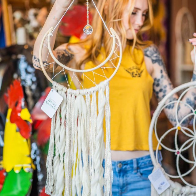 woman holding macrame with crystal wall hangings in the Simply Ashland downtown store